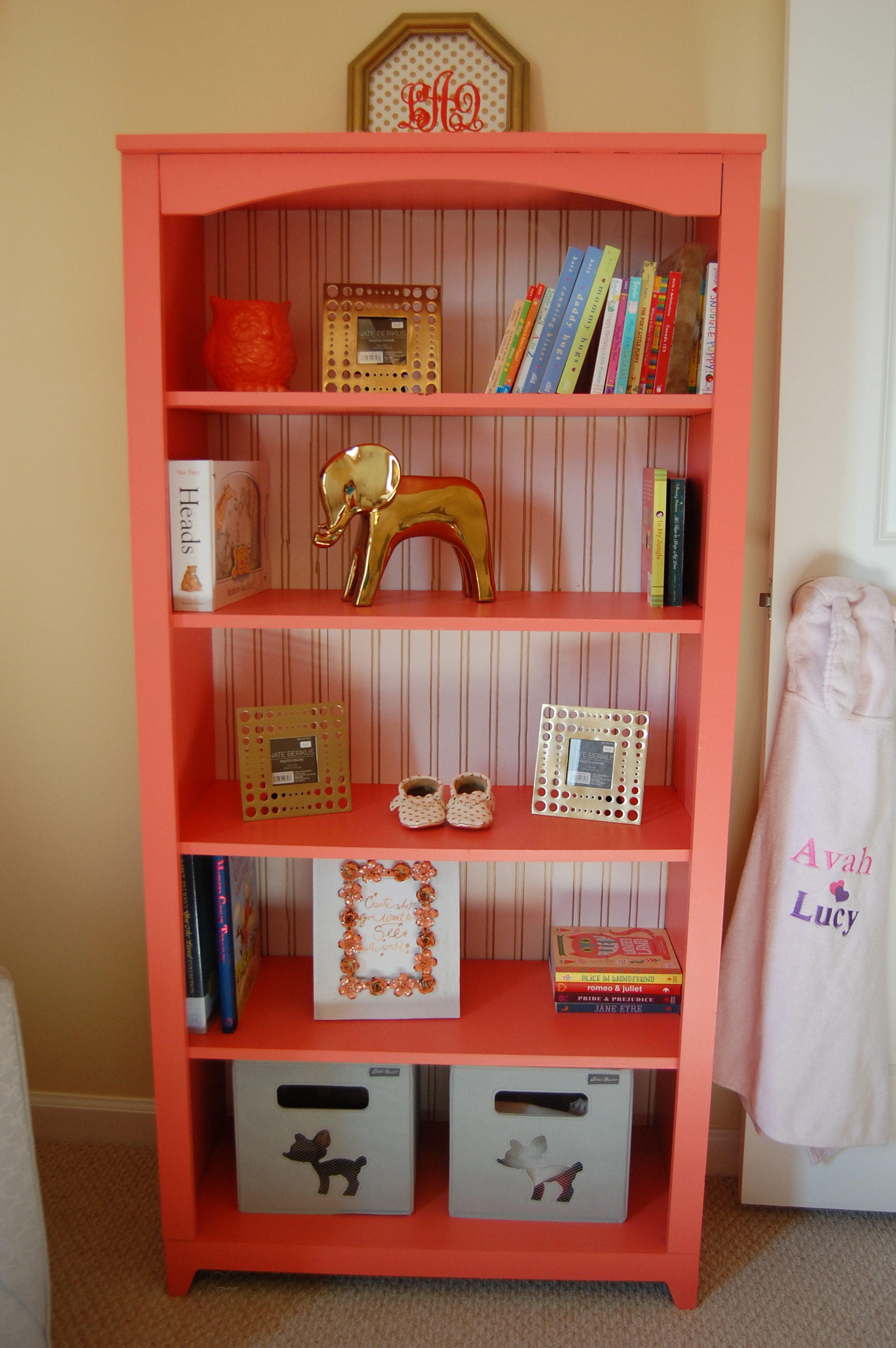 Coral Painted Bookcase with Gold Lines Wallpaper on the Back