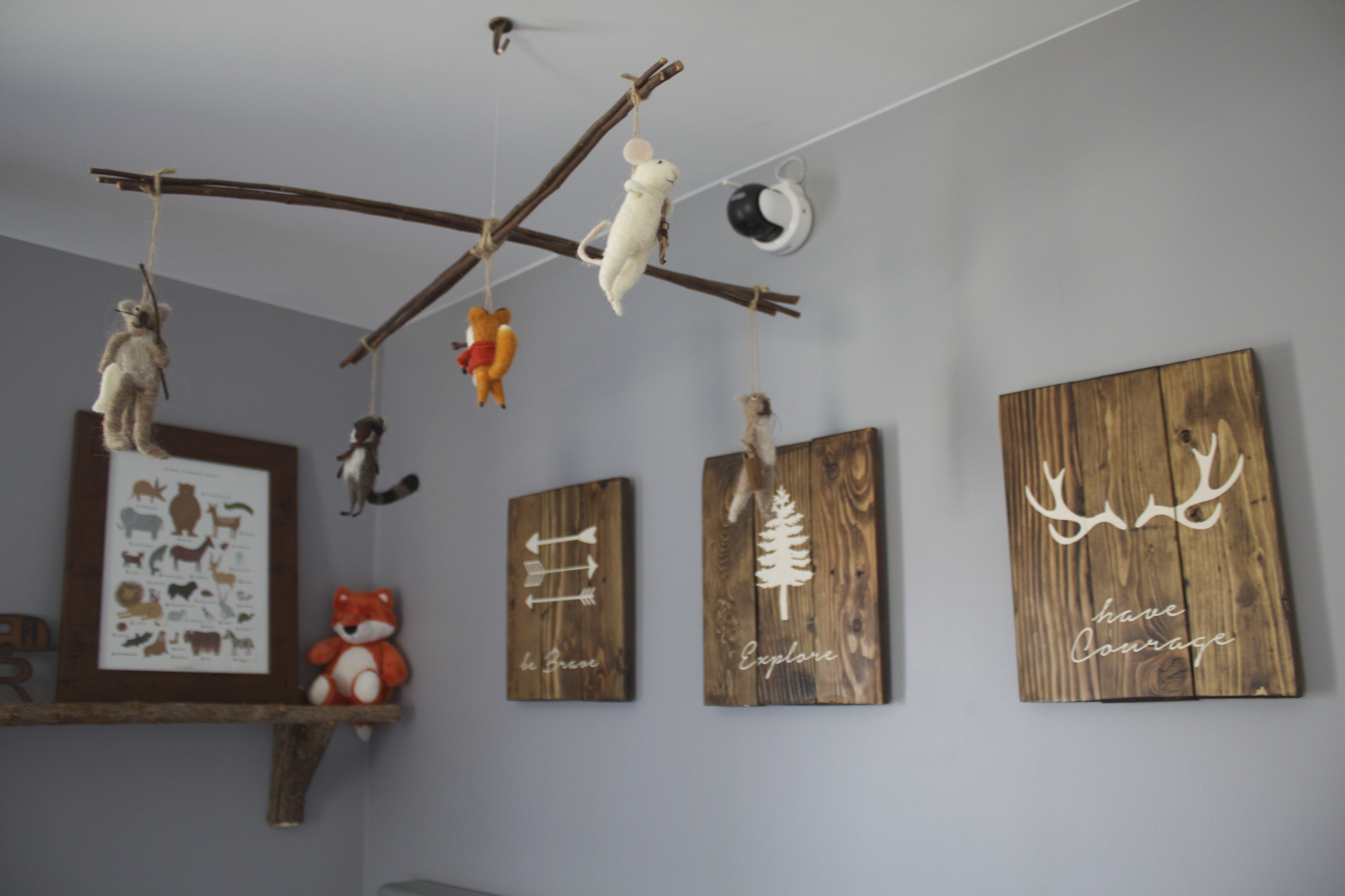 Reclaimed Wood Signs over the Crib in this Woodland Nursery