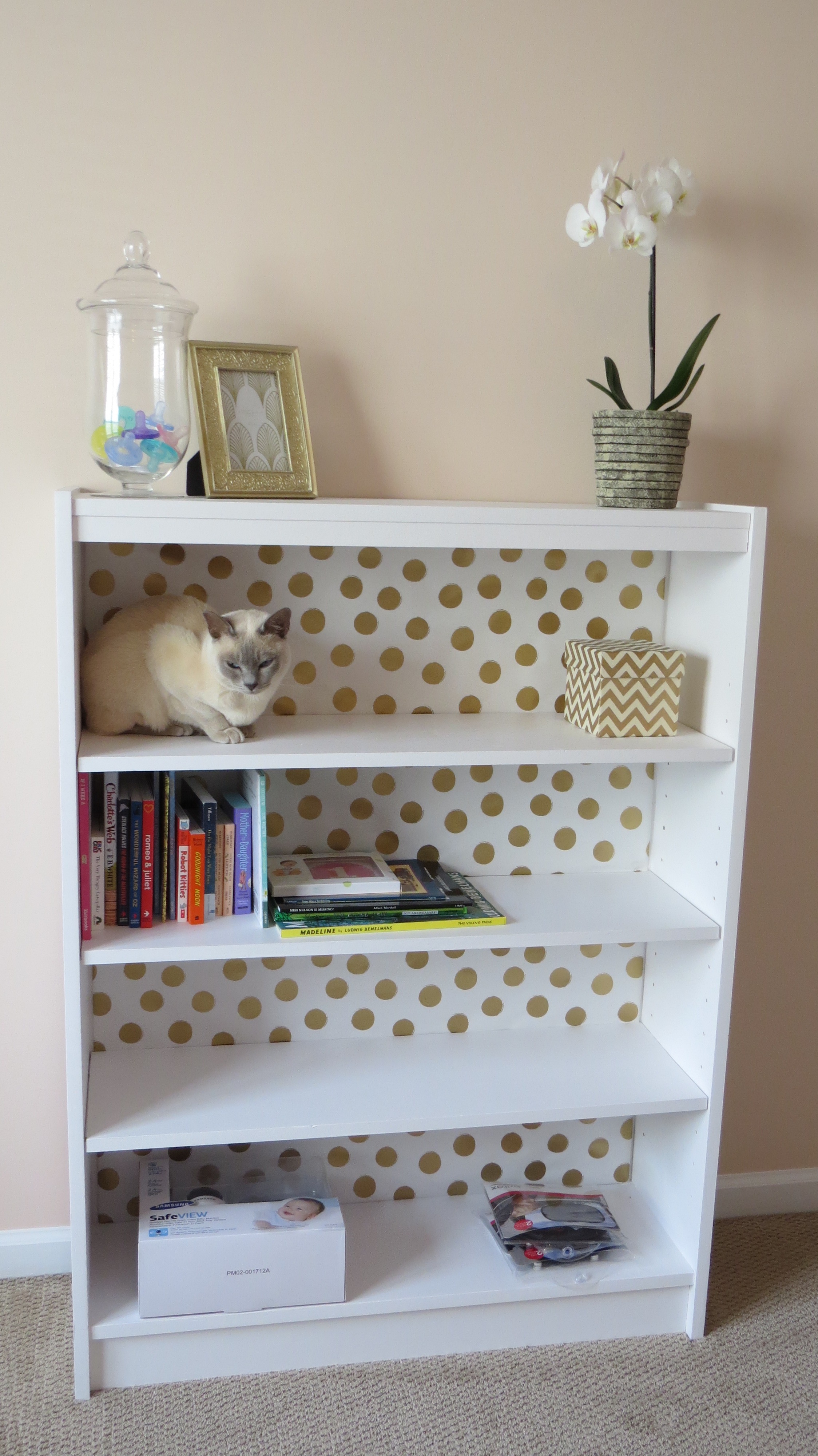 Gold foil polka dot wrapping paper to line the back of the bookcase
