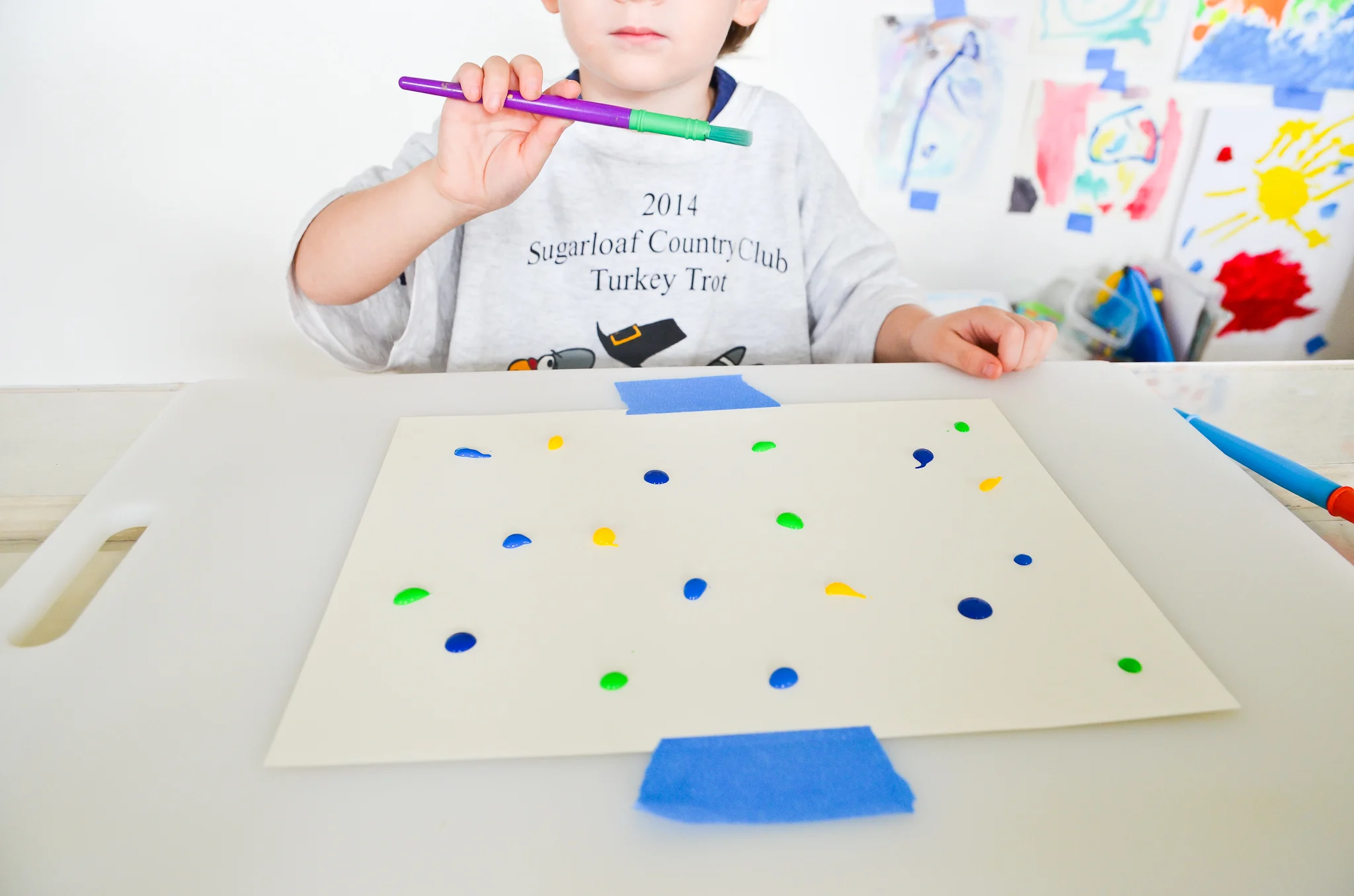 Toddler painting with toys