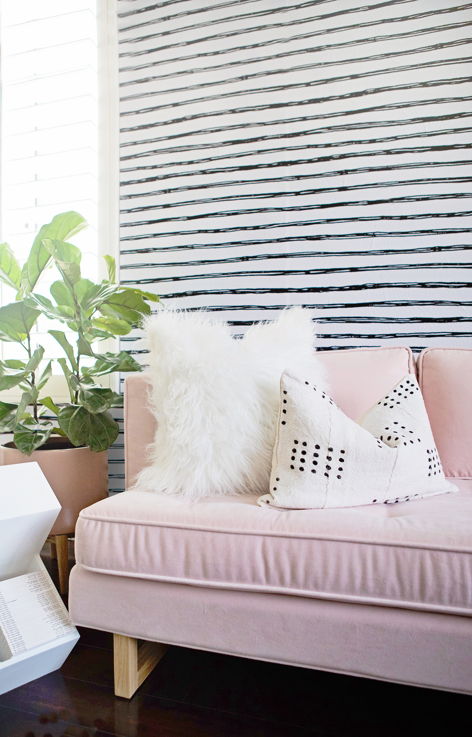 Black and White Striped Wallpaper and Pink Couch in Girl's Nursery