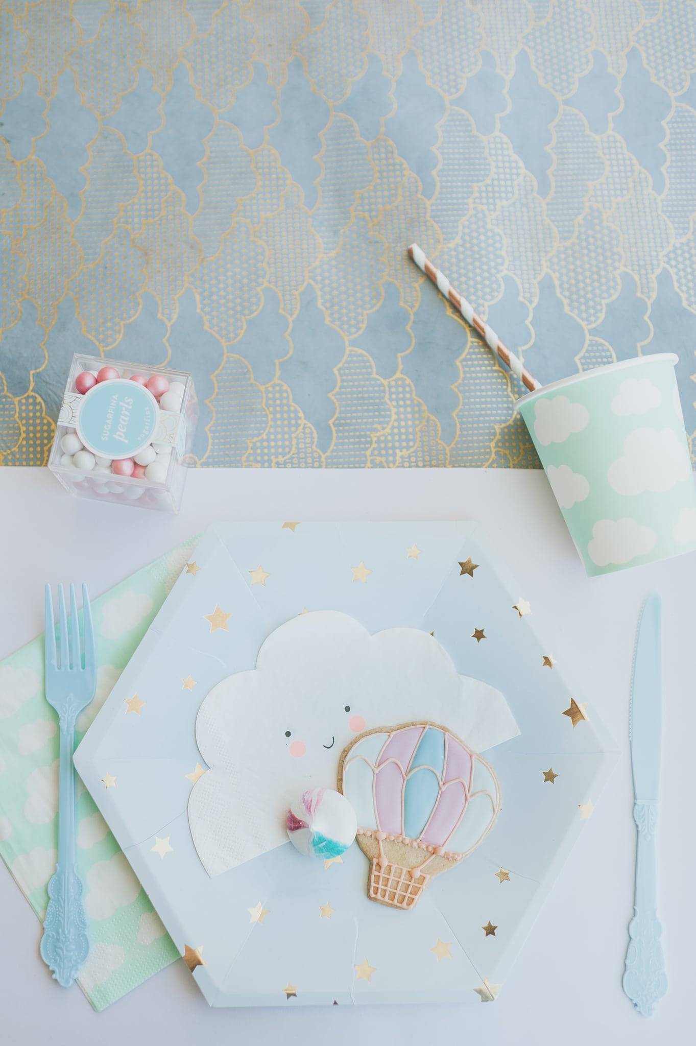 Hot air balloon baby shower place setting with blue and gold star plate cloud cups and napkins and hot air balloon cookies - Project Nursery