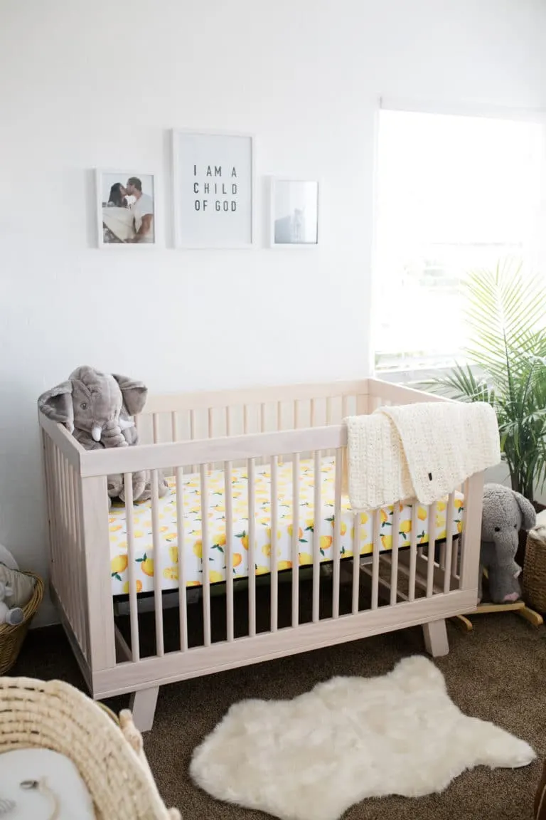 Modern Boho Nursery with a Punch of Tropics Natural Wood Crib with Lemon Sheet