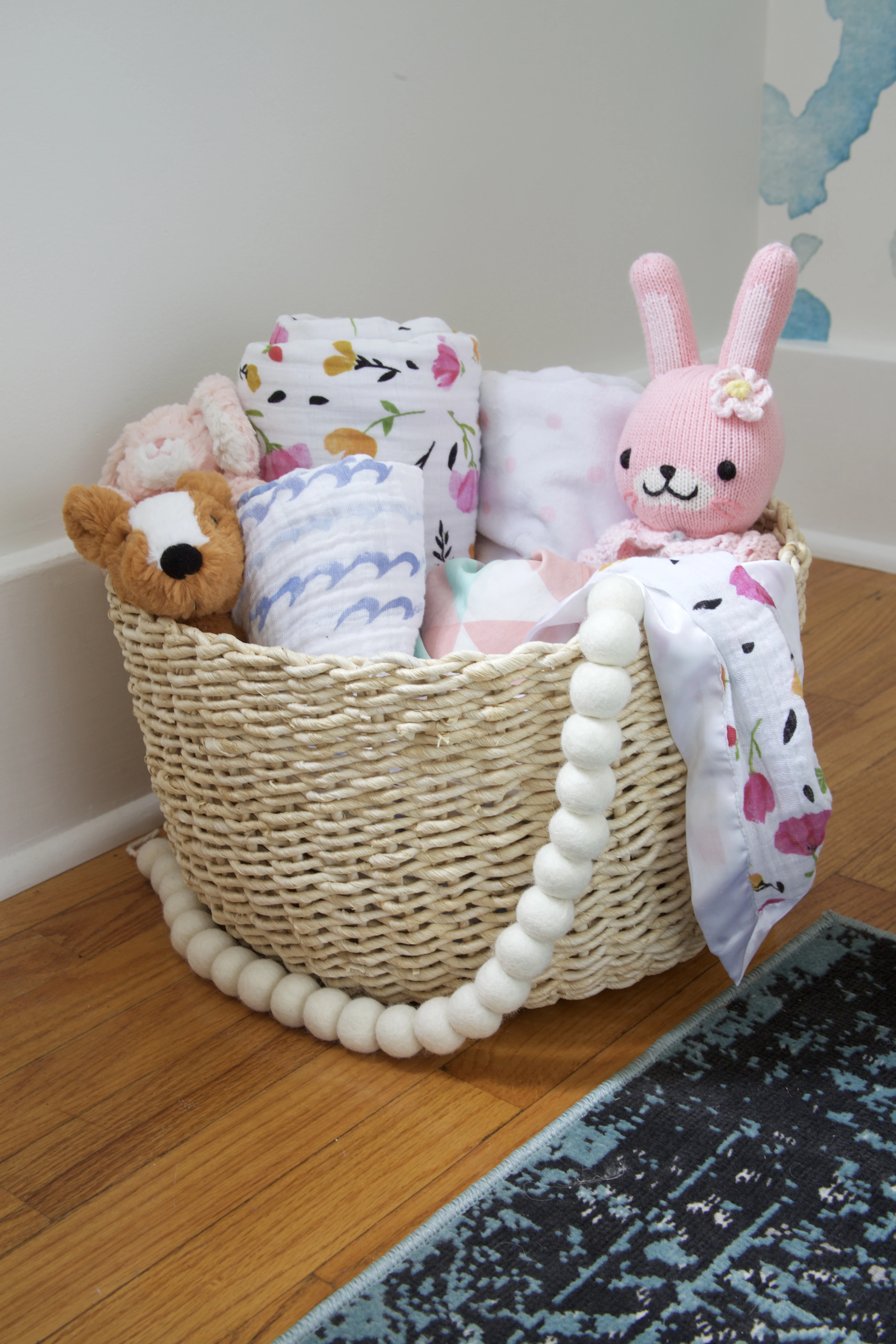 Basket of Swaddle Blankets and Toys - Project Nursery