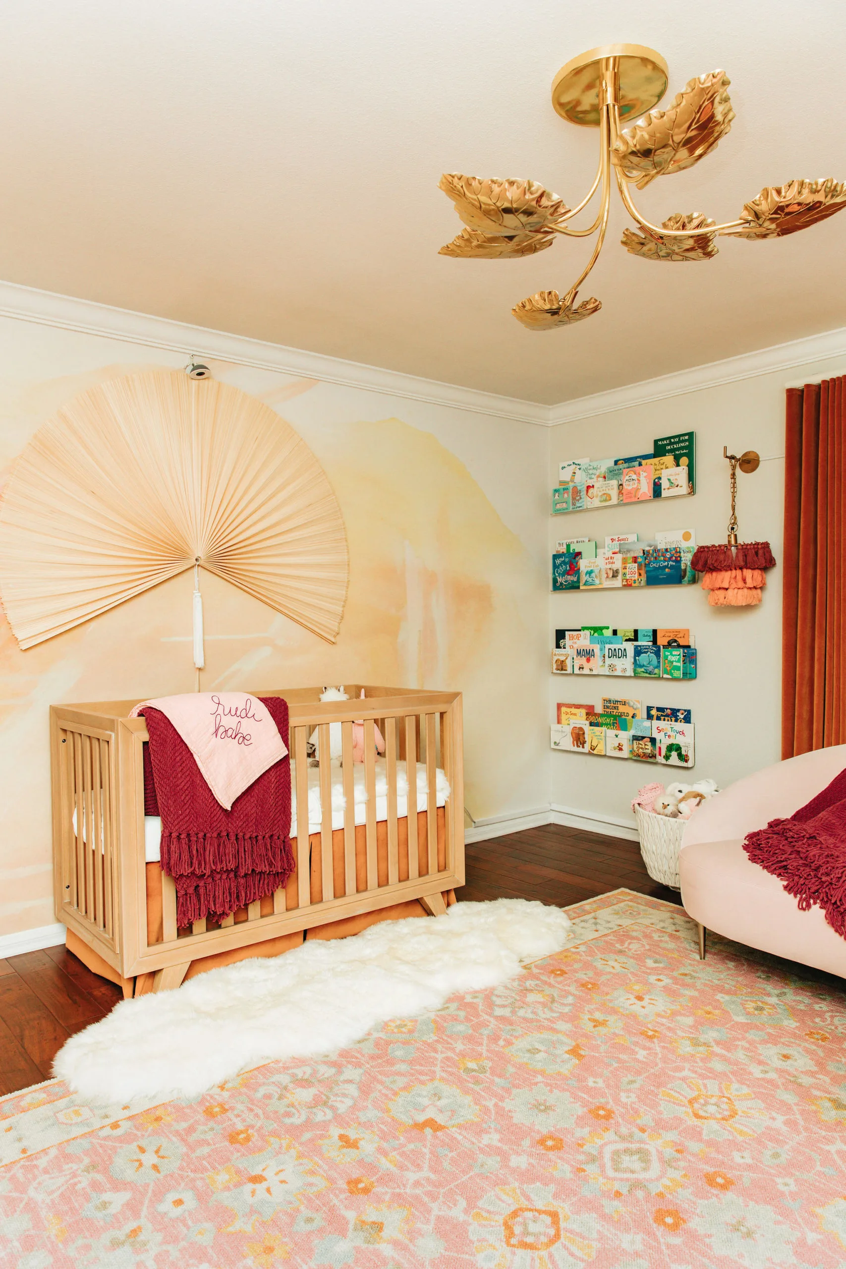 Fan Over Natural Wooster Crib with Abstract Sunrise Wallpaper