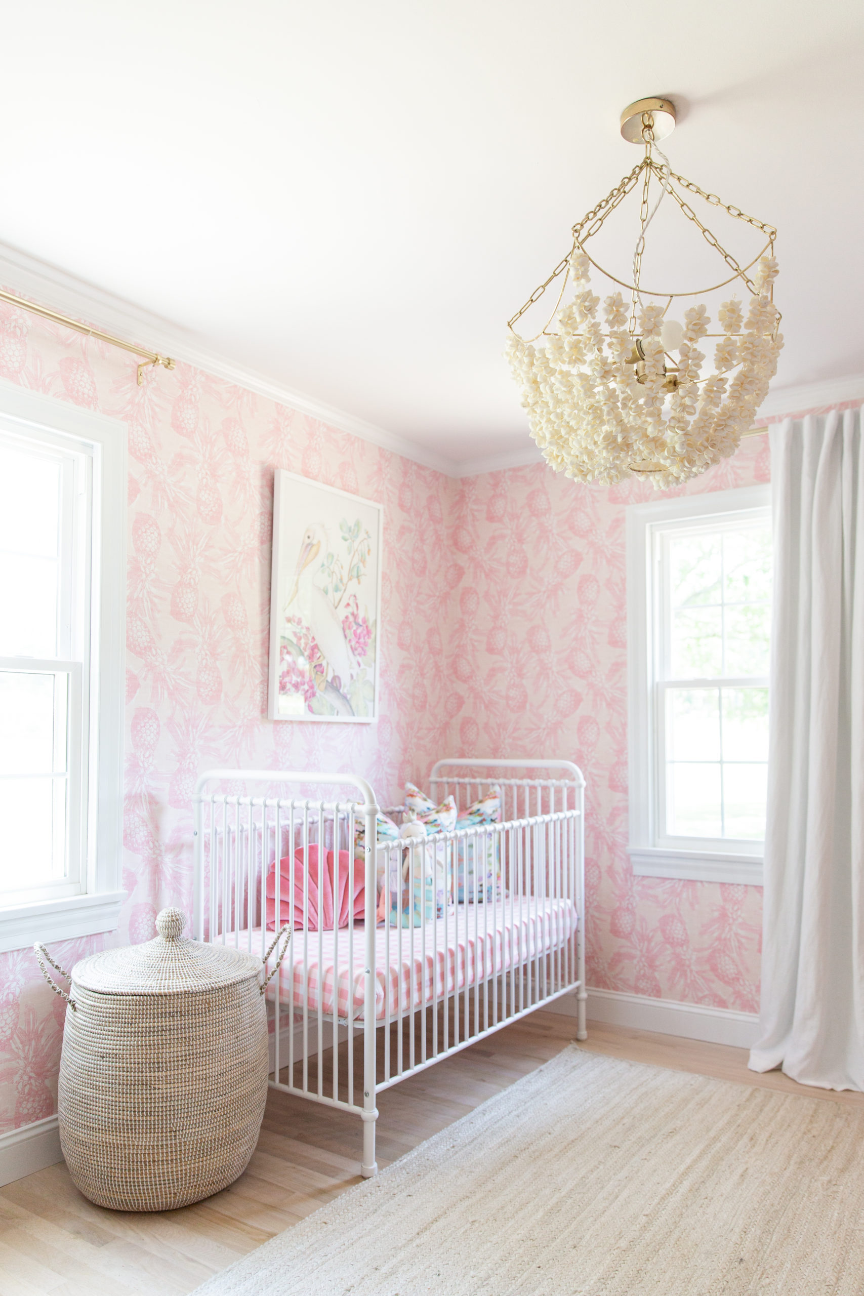 Girly Coastal Nursery with Pink Pineapple Wallpaper and Shell Chandelier