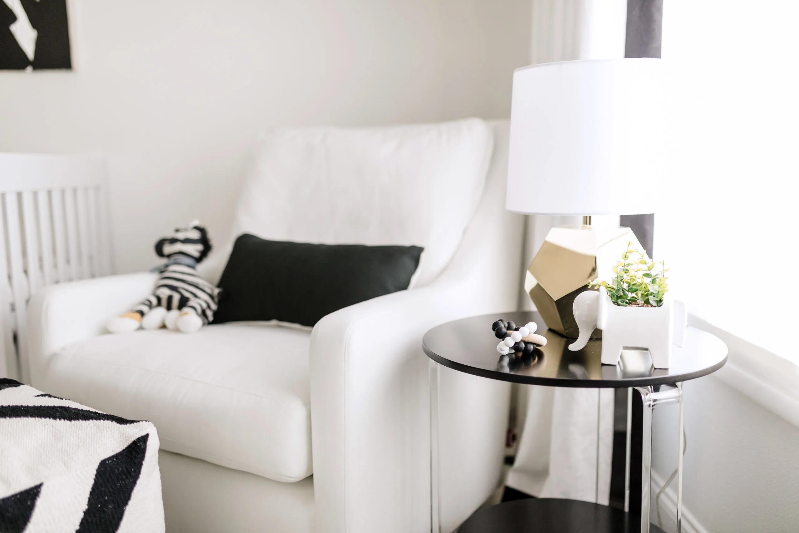 White Glider and Black Acrylic Side Table in Nursing Nook