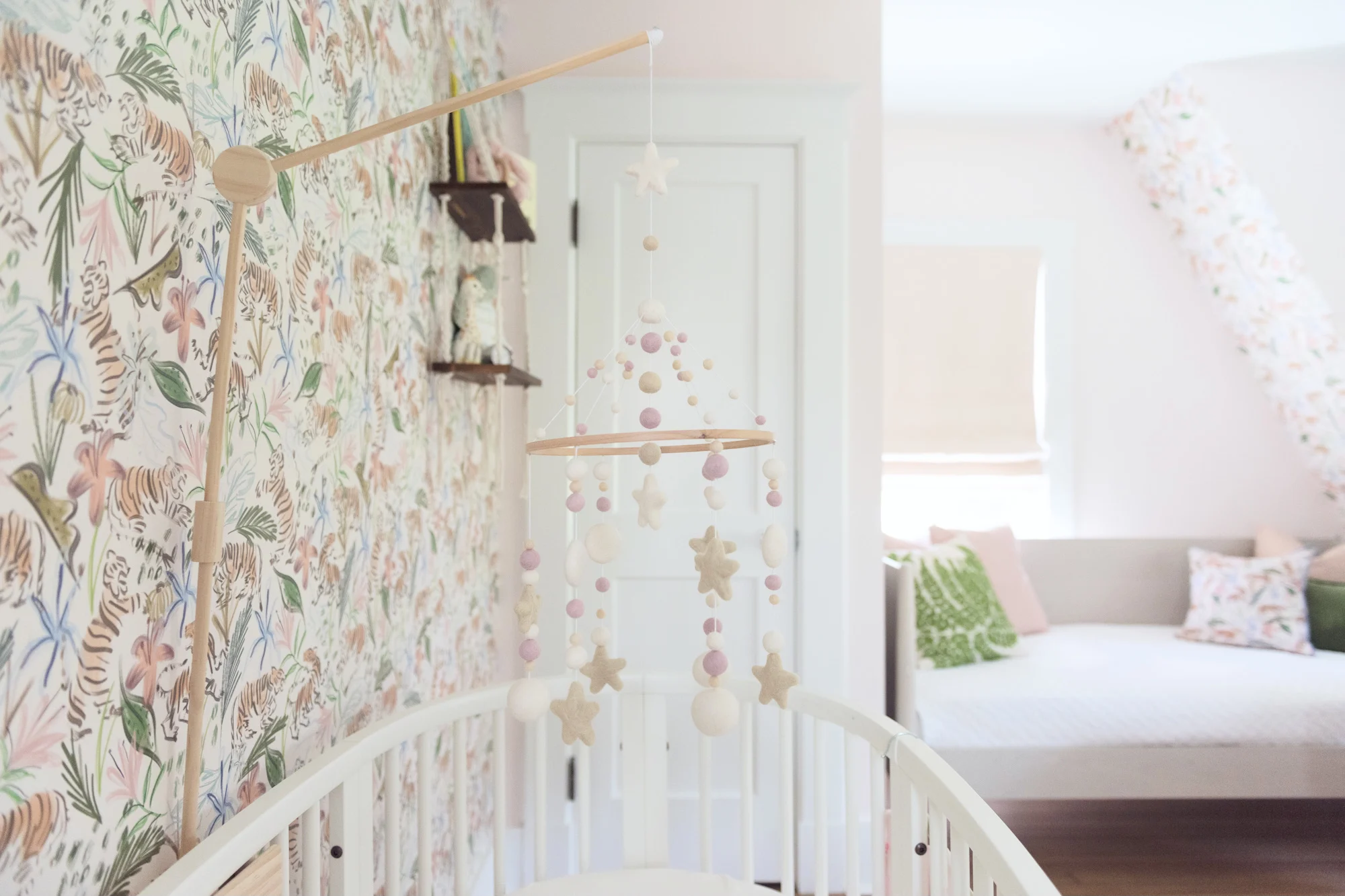 Felted Mobile in Girl's Nursery featuring pink safari wallpaper